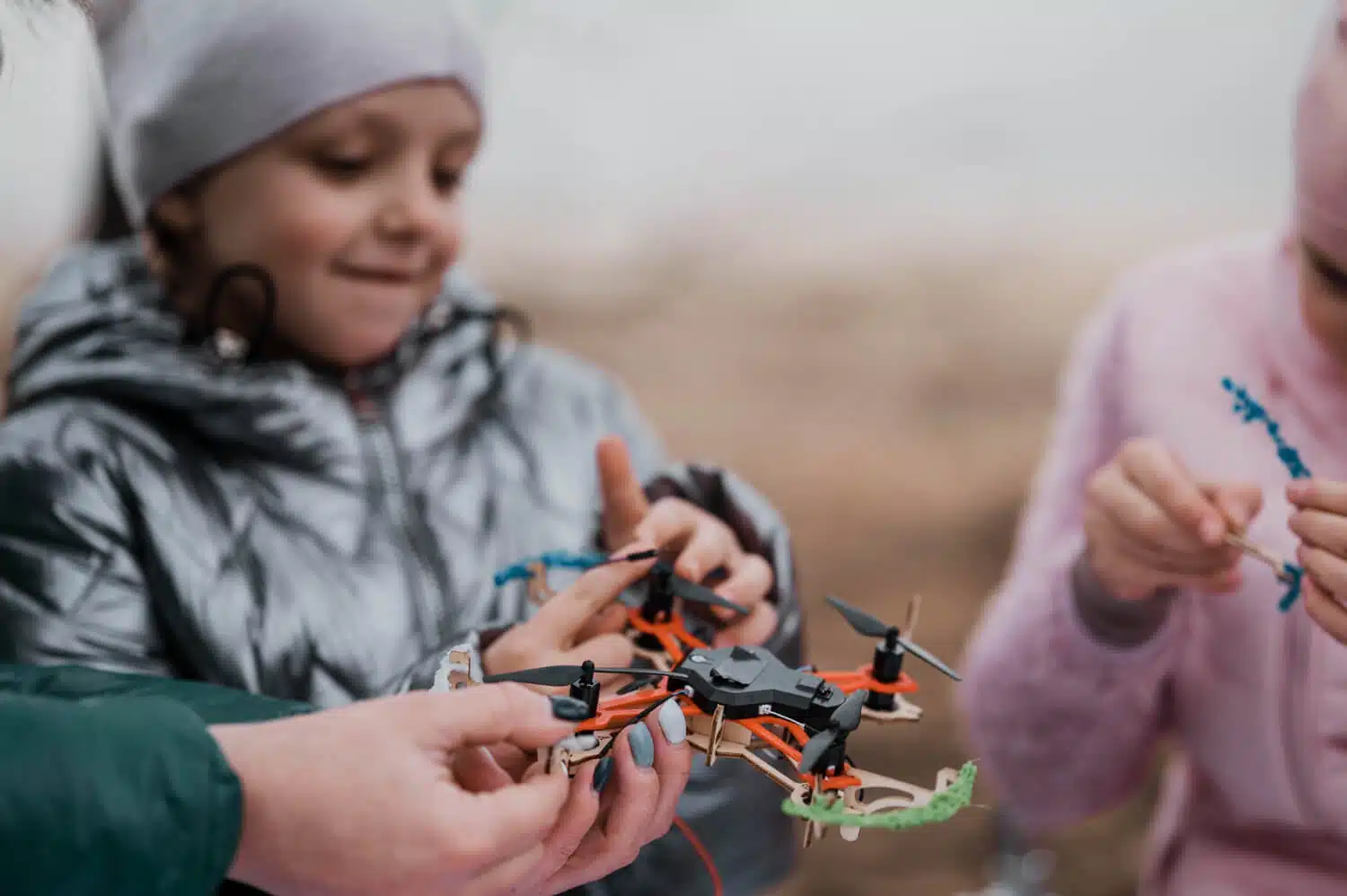 Crianças participando de uma atividade ao ar livre relacionada à programação e robótica, como programar drones ou trabalhar com robôs exploradores